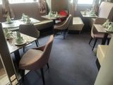 tables and chairs in a restaurant with a window in the background