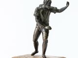 bronze statue of a man holding a tennis racquet on a marble base