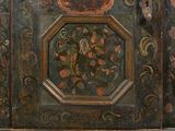 an old wooden cabinet with a painting on the door