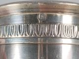 a silver vase with a decorative design on it