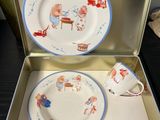 two plates and a cup in a suitcase on a table
