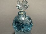 a blue glass bottle with a flower on top