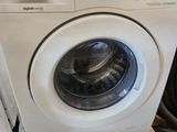 une machine à laver posée sur une palette dans un magasin