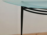 a glass table with a black metal base and a glass top