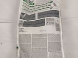 a newspaper laying on a bed with a pillow