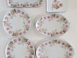 several plates and trays are arranged on a white surface