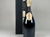 une bouteille de champagne devant une boîte noire