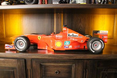 une maquette de voiture de course posée sur une étagère en bois