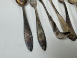 a lot of silver spoons and spoons on a table