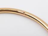 a close up of a gold bang bracelet with a diamond in the middle