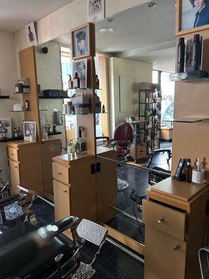 une photo d'un salon de coiffure avec de nombreux fauteuils