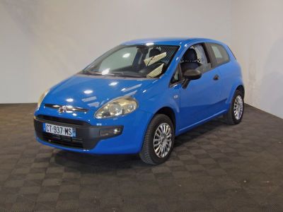 the small blue car is parked in a large room
