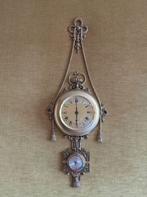 une horloge accrochée au mur, entourée d'une chaîne