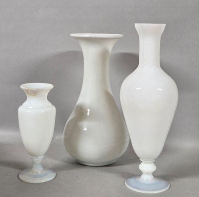 three white vases sitting next to each other on a table