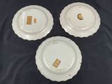 three white plates are sitting on a black surface
