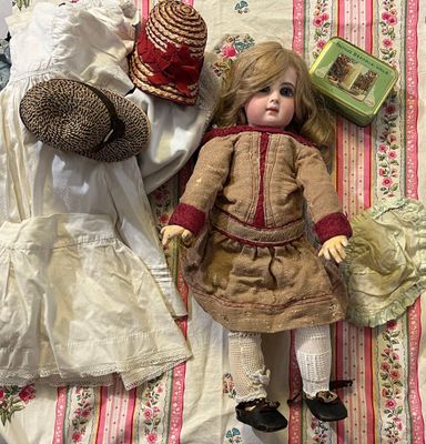 a doll laying on a bed next to a teddy bear