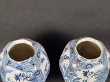 pair of blue and white vases with floral designs on them