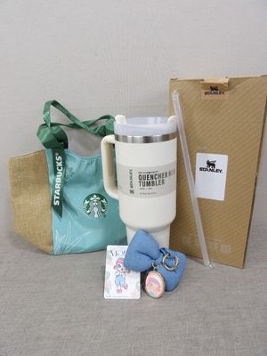 un gobelet Starbucks, un sac et un porte-clés posés sur une table