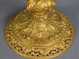 gold plated candle holder with figurine of a woman holding a flower