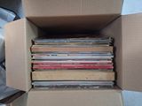 a cardboard box full of cds sitting on the floor