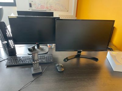 un bureau équipé de deux écrans et d'un clavier