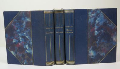 trois livres bleus empilés les uns sur les autres sur une surface blanche