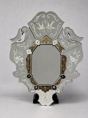miroir à face réfléchissante, orné de motifs blancs et dorés, monté sur un socle noir