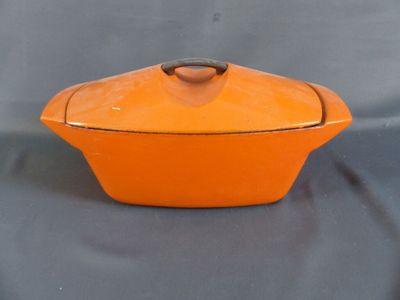 un plat à gratin orange avec un couvercle, sur fond gris