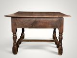 an old wooden table with turned legs and a wooden top