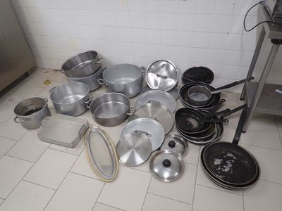 il y a beaucoup de casseroles et de poêles par terre dans la cuisine