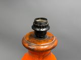 an orange fire hydrant with a black top on a gray background