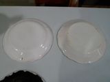 deux assiettes blanches sur une table avec un bol noir
