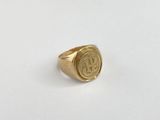 a close up of a gold ring with a monogram on it