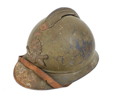 un vieux casque militaire muni d'une lanière en cuir, sur fond blanc