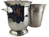 a silver vase and a silver cup next to each other