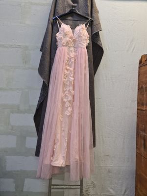 a dress hanging on a clothes rack in the corner of a room