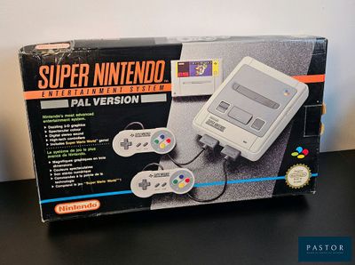 une vieille console Nintendo posée sur une table, à côté d'une boîte