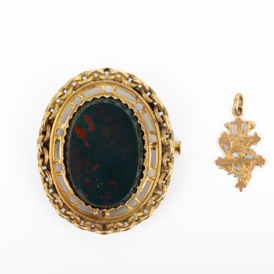 un gros plan d'un pendentif et d'une croix sur une surface blanche