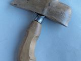 a wooden cleaver with a wooden handle on a white surface