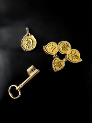 deux pièces d'or et une clé posées sur une surface noire