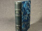 an old book sitting on top of a table with a blue cover