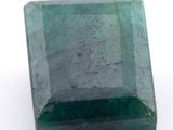 gros plan d'une pierre d'émeraude verte sur une surface blanche