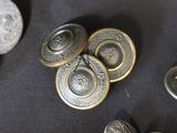 some metal buttons are laying on a black surface