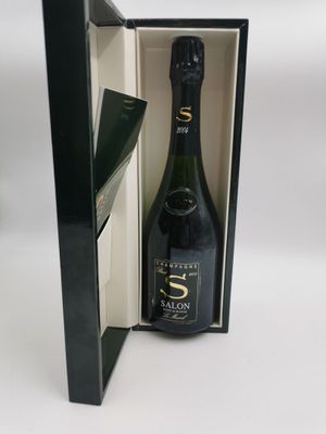 une boîte ouverte contenant une bouteille de champagne, posée sur une surface blanche