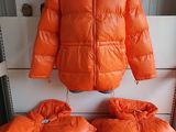 an orange jacket and two pillows are on a white bench