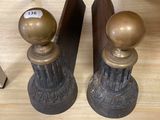 two bookends on a table with a clock in the background