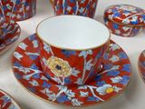 a red and blue tea cup and saucer set on a white table