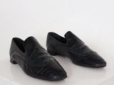 paire de chaussures en cuir noir sur une surface blanche avec un fond blanc