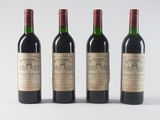three bottles of wine are lined up on a white surface