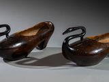 pair of carved wooden swan bowls on stand on white surface